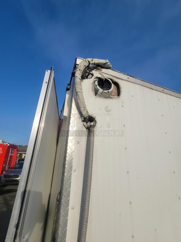 2019 24' Quality food concession trailer corner view, featuring external piping and aluminum paneling.