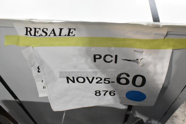 Alt text: Close-up of a Scotsman MC1030SA-32A ice machine showing "RESALE" and auction details on paper tags.