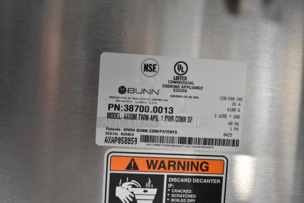 Brand new 2025 Bunn Axiom Twin APS coffee brewer with airpot, hot water dispenser, and safety warning label.