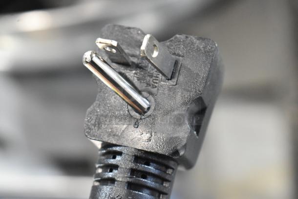 Close-up of a power plug for the Avantco 184T3600D conveyor toaster, showing three prongs and manufacturer’s markings.