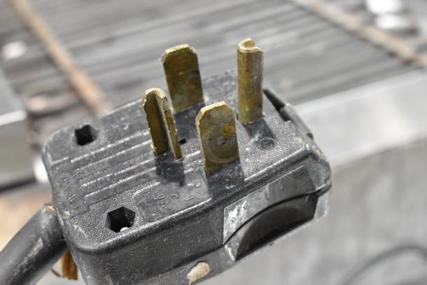 Close-up of a three-prong plug for a Star Max Stainless Steel Commercial Electric Griddle, showing wear and voltage details.