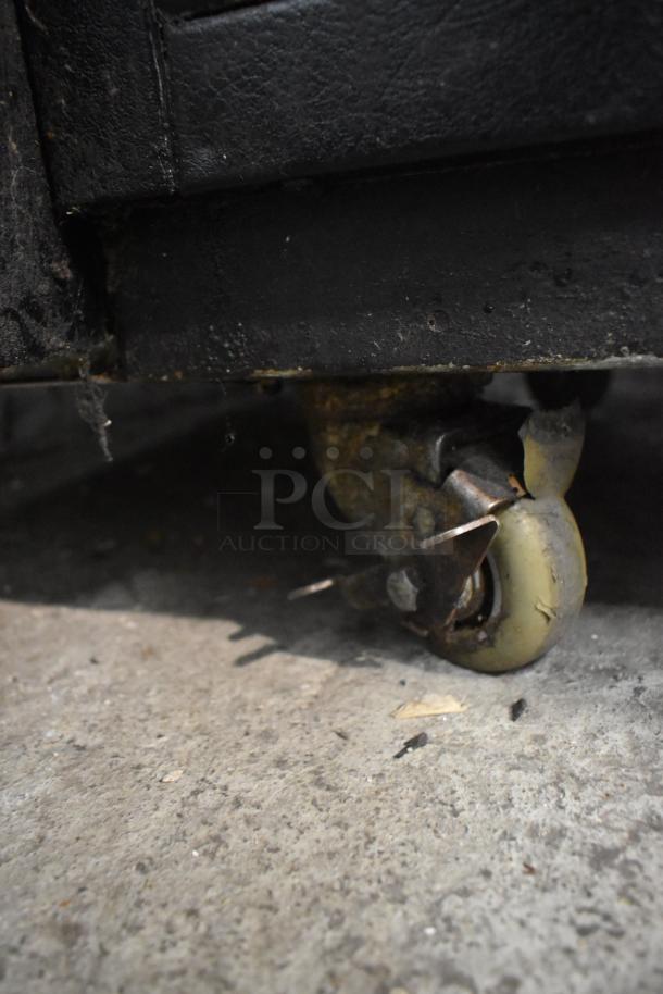 True TBB-24-48G-SD undercounter cooler on worn commercial caster, highlighting rust and dirt accumulation.