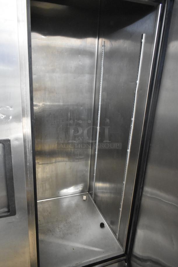 True TS-43 stainless steel commercial 2-door reach-in cooler interior. Slight wear visible. 115 volts, 1 phase.