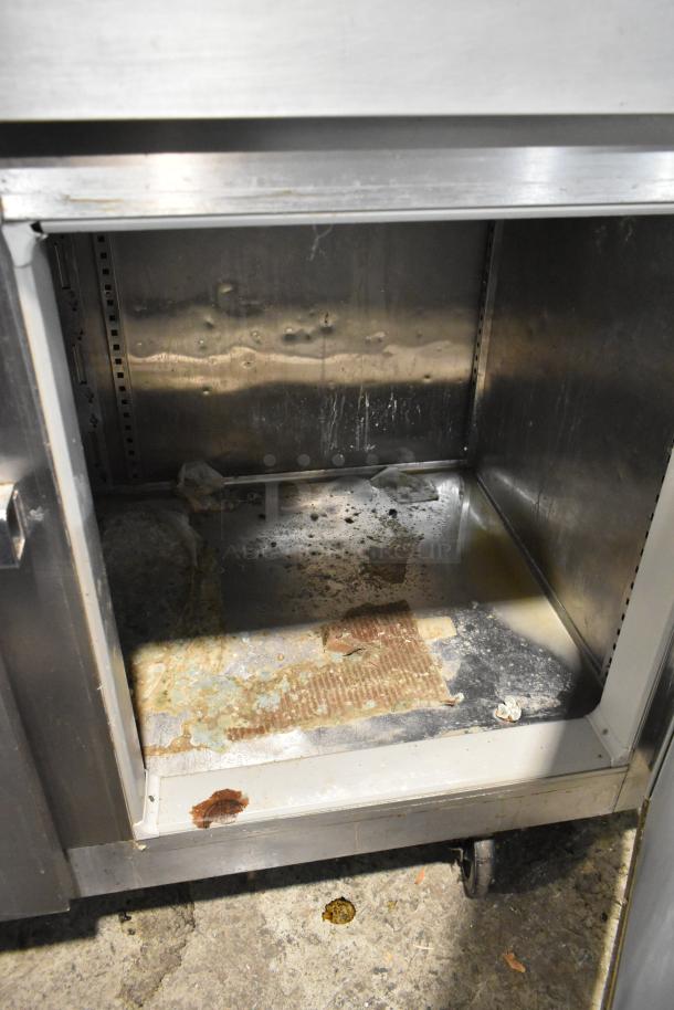 Victory FS-2D-S7-EW-HD stainless steel commercial cooler, 4 half doors, on casters, visible wear inside. 208/230V, 1 phase.