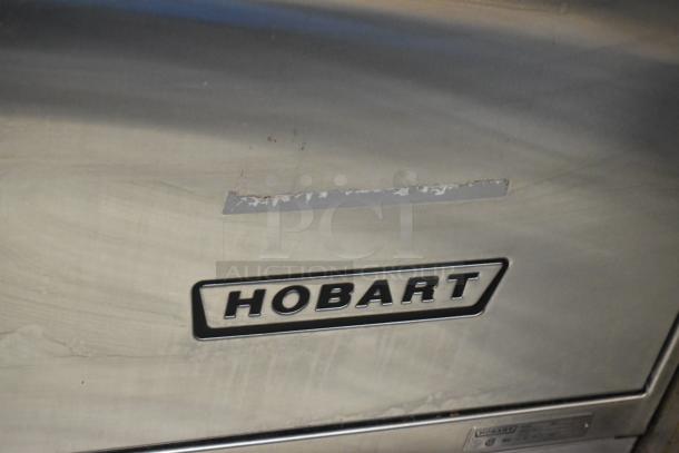 Hobart LX30H stainless steel commercial undercounter dishwasher, showing some surface wear. Logo and model tag visible.