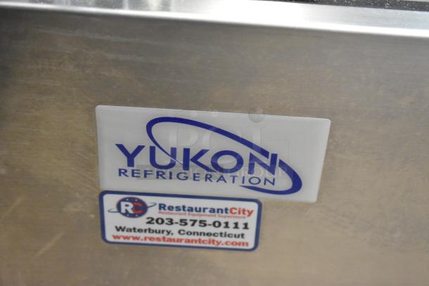 Yukon YRDC-FG-60 stainless steel deli display case, commercial floor style, 115 volts, 1 phase. "Yukon Refrigeration" label visible.