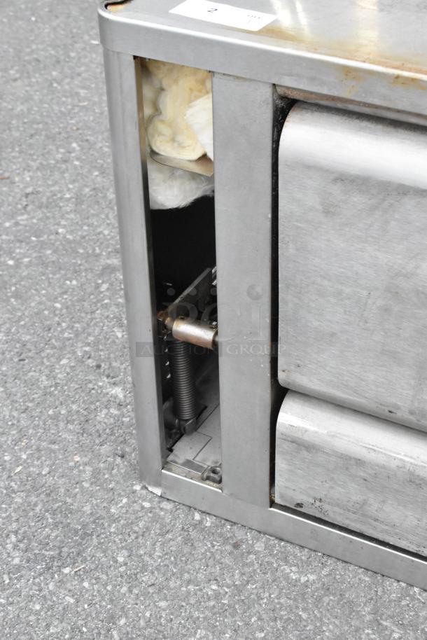 Blodgett 1060B stainless steel commercial propane gas pizza oven, showing lower side with internal components exposed.