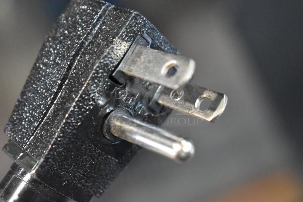 Close-up of a three-prong power plug for a 2024 True STG2RPTVLD-2G-2S-HC cooler. Black textured body.