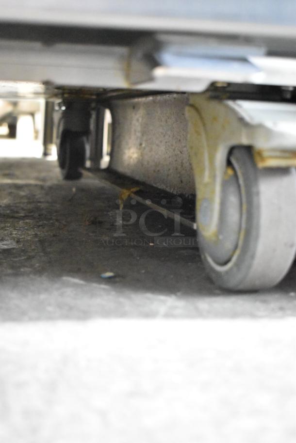 JBT 2ND-GEN-MFJ-HE citrus juicer on commercial casters, showing base and wheels. Stainless steel, tested, 120V, 1-phase.