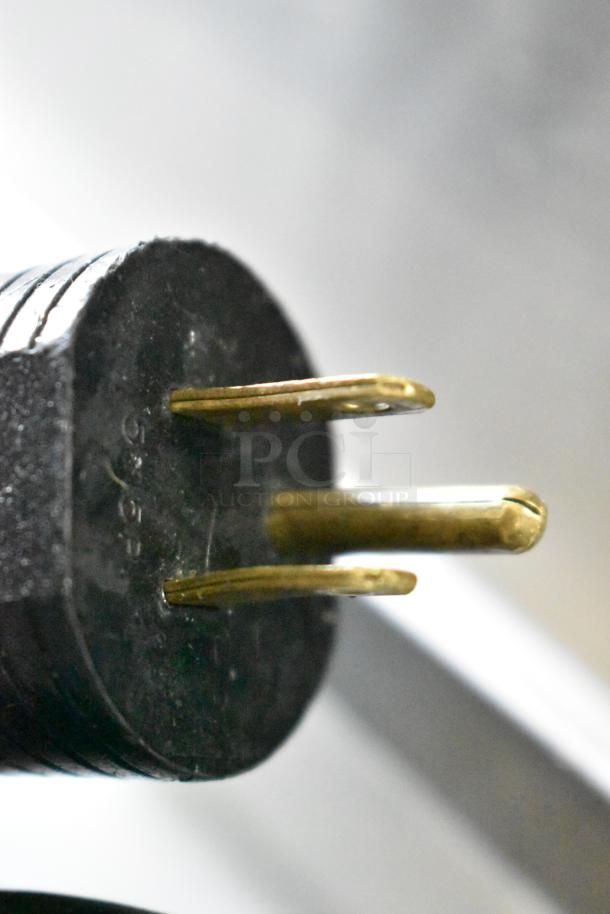 Close-up of a three-prong plug for a JBT 2ND-GEN-MFJ-HE commercial citrus juicer, suitable for 120 volts, 1 phase.