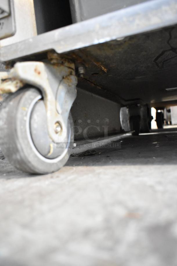 JBT commercial citrus juicer model 2ND-GEN-MFJ-HE on casters, showing close-up of wheel. 120 volts, 1 phase.