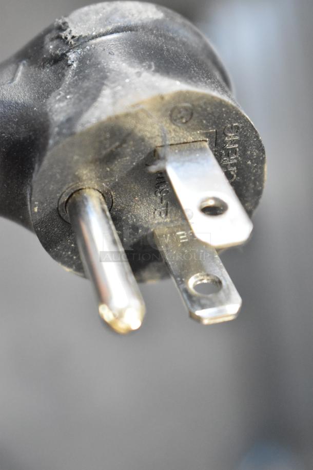 Close-up of a power plug for the True T-19F-HC commercial freezer, showing prongs and markings on the plastic casing.