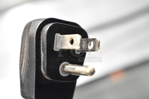 Close-up of a standard three-prong electrical plug for a Habco SE12 cooler, showing clear prongs and housing.