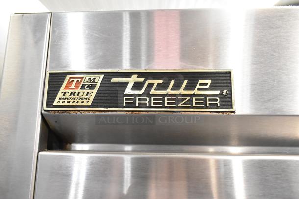 True T-19F stainless steel commercial freezer door with True Manufacturing Company logo. Features poly-coated racks, on casters.
