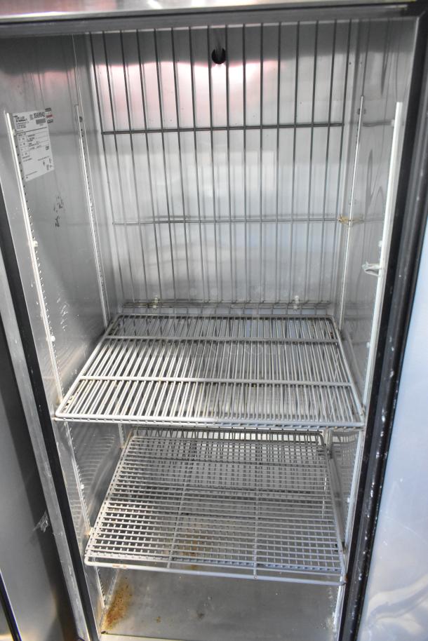True T-19F stainless steel commercial freezer with poly-coated racks, on casters. 115 volts, 1 phase. Interior view.