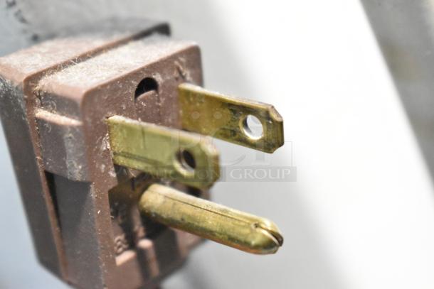 Close-up of a dusty electrical plug for a General Electric GE STS16ABSARWW cooler, 115 volts, 1 phase.