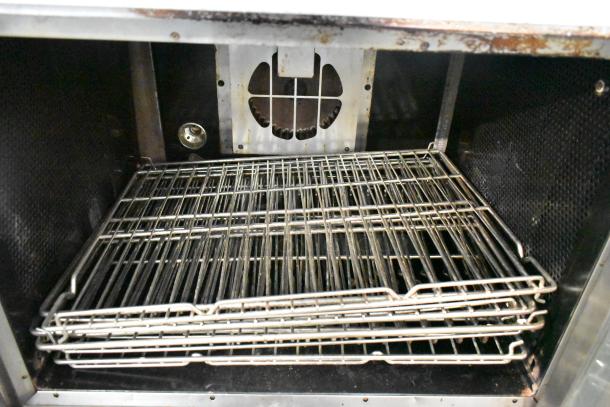 Vulcan stainless steel commercial convection oven interior with metal racks and thermostatic controls, view through doors.