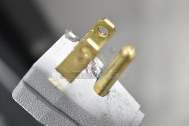 Close-up of a power plug with visible dust, likely part of a True TG1R-1S-HC commercial cooler. 115 volts, 1 phase.
