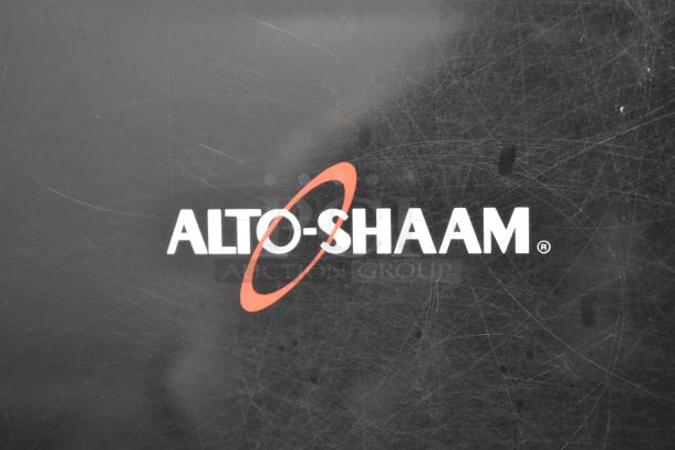 Alto Shaam AR-7T logo on stainless steel commercial electric rotisserie oven, indicating the brand and model.