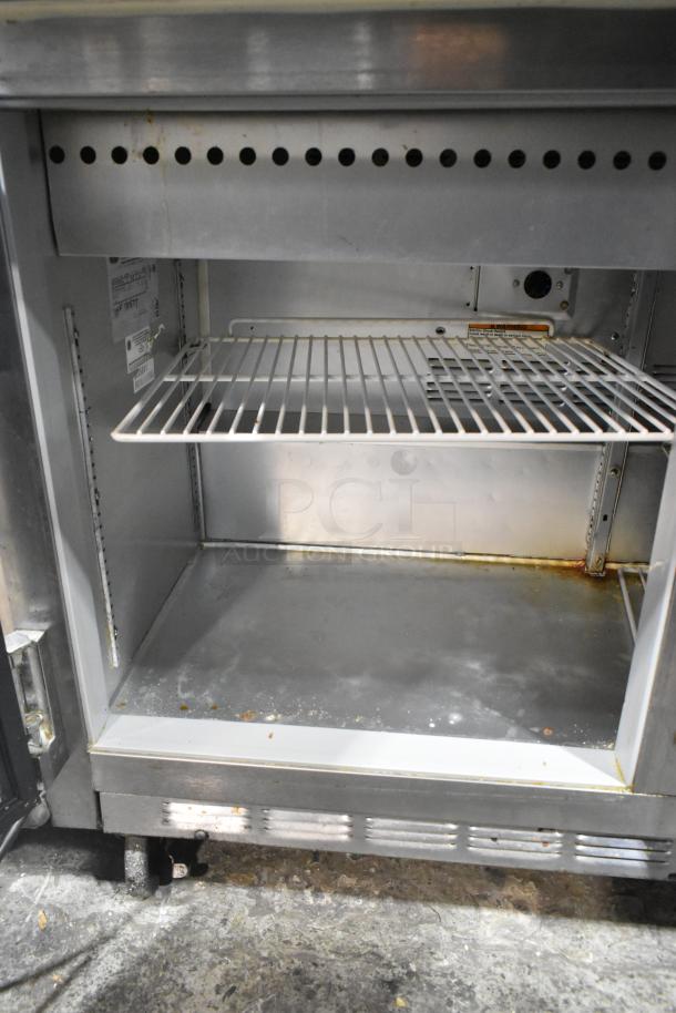 Beverage Air stainless steel prep table; interior view, wire shelf, signs of use. Commercial casters, 115V, 1 Phase.
