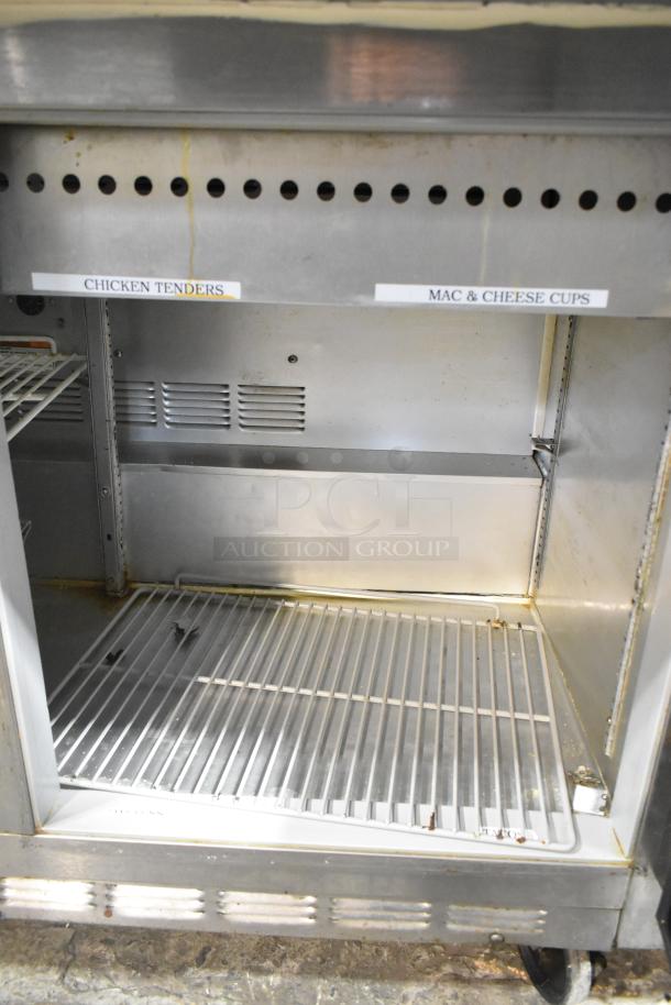 Beverage Air stainless steel commercial sandwich prep table with storage shelf, labels for food items; on casters.