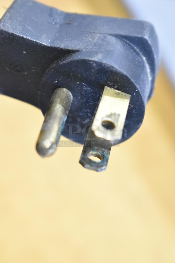 Close-up view of a three-prong electrical plug, part of the Beverage Air commercial prep table.