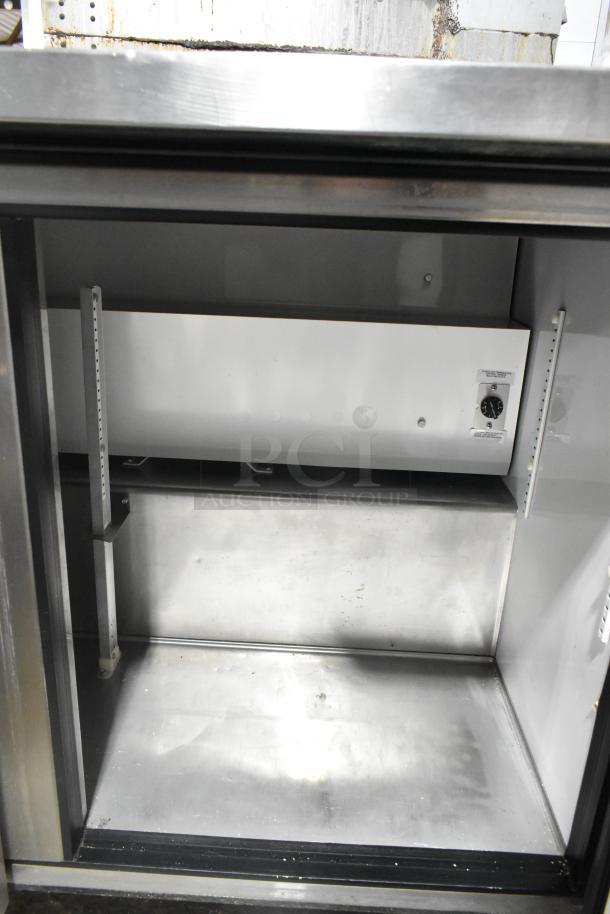 True TWT-72 stainless steel 3-door cooler interior. Features shelving rails. 115 volts, 1 phase, commercial-grade.