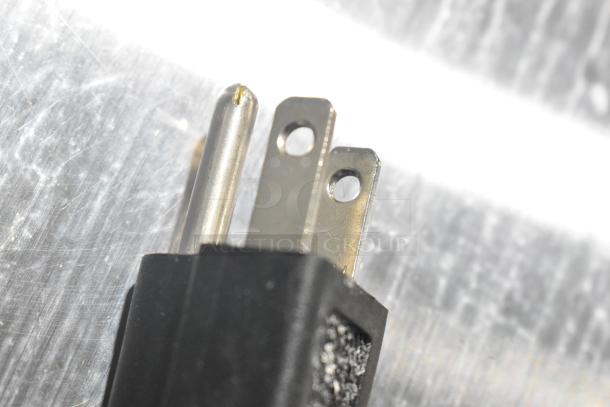 Close-up of a metal three-prong power plug for the Avantco 178UBB72SHC commercial back bar cooler, showing detailed prongs and cord.