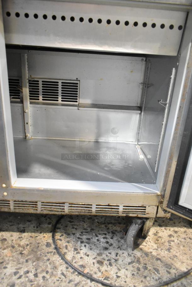 Beverage Air stainless steel prep table, model SPE48-18M-HMP, with casters. Interior view, showing vent and shelf tracks.