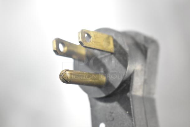 Close-up of a three-prong plug for the Beverage Air UCR48A commercial cooler, showing brass connectors and black housing.