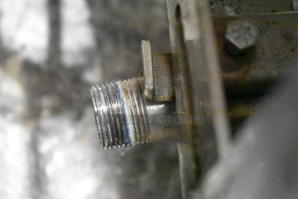 Close-up of a connector or fitting on a Cleveland PGM3002 natural gas pressure floor steamer; stainless steel.