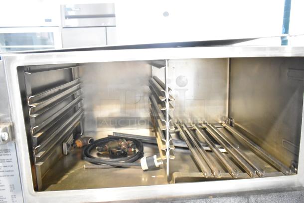 Cleveland PGM3002 stainless steel commercial steamer interior view, 16-pan capacity, pressure floor model, showing boiler base details.