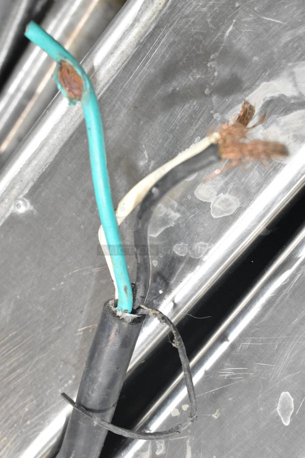 Damaged wiring of a Taylor 340-27 stainless steel frozen beverage machine, exposing copper, needing repair.