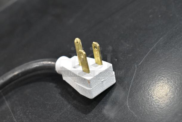 True Commercial Cooler Power Plug, GDM-41SL-48-HC-LD, 115 Volts. Black cord and white plug on dark surface.