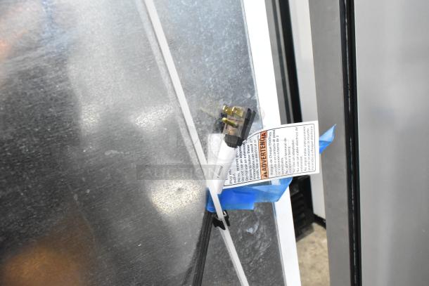 Whirlpool metal reach-in cooler with freezer, 115 volts, 1 phase, visible power cord with warning label attached.