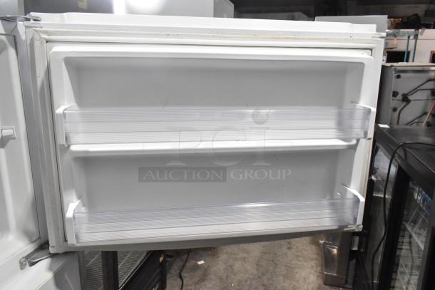 Whirlpool metal reach-in cooler with freezer, 115 volts, 1 phase. Features double shelves, clean interior, white finish.