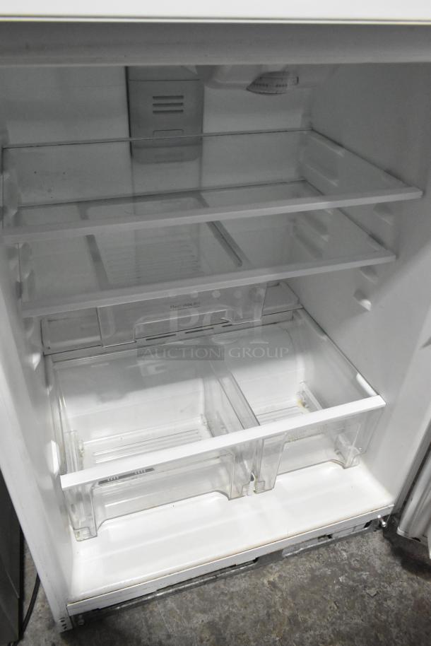 Whirlpool metal reach-in cooler with freezer, 115 volts, 1 phase. Features glass shelves, two clear drawers, and clean interior.