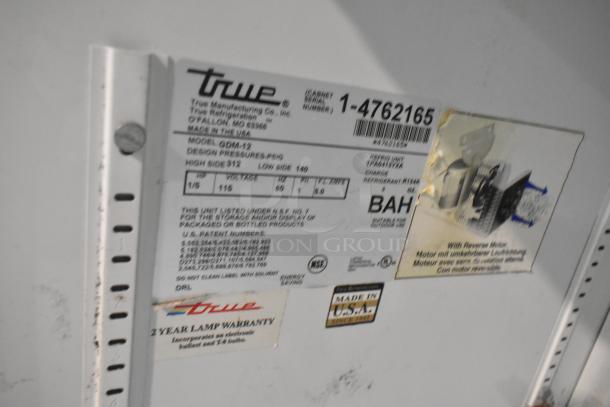 True GDM-12 cooler label indicating model, 115 volts, 1-phase power, metal build, with poly coated racks, made in USA.