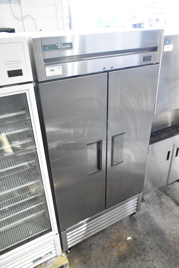 2018 True T-35-HC stainless steel 2-door reach-in cooler with poly-coated racks. Features True branding and control panel.