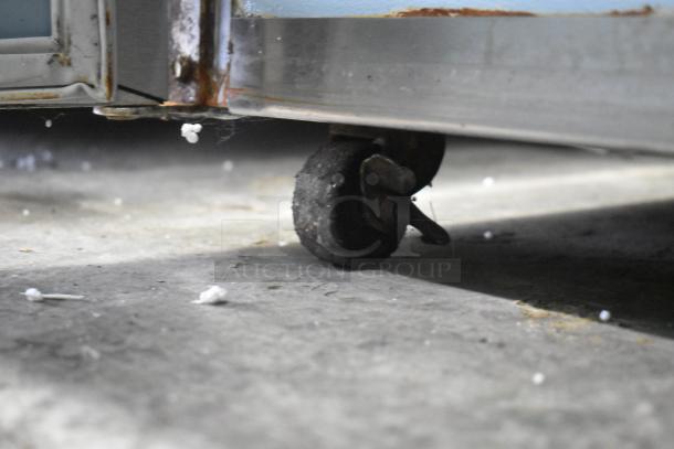 Delfield 406CA-DHL-DD1 undercounter cooler's rusted stainless steel bottom and worn commercial caster.