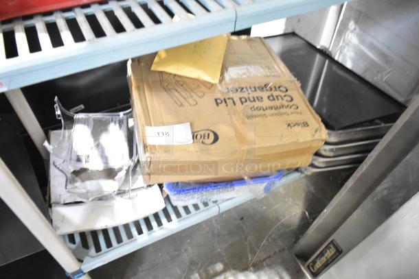 Tiered lot featuring a Choice cup and lid organizer in a labeled box, accompanied by drop-in bin lids and assorted items.