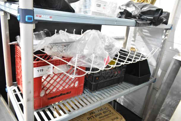 Mixed items on shelves, including a white rack, crates, and a pelican headpiece in a plastic bag. Tags show auction lot numbers.