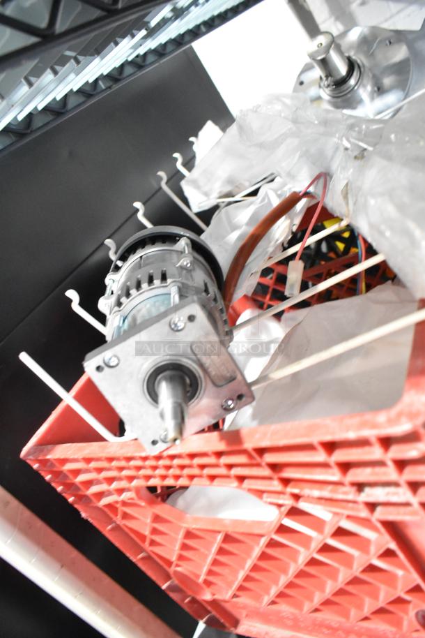 Tiered auction lot including a pelican head piece and rack. Features a motor component in a red crate. Condition appears used.