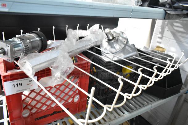 Auction item lot with various components, including a motor assembly and a wire rack, stored in red and black crates.