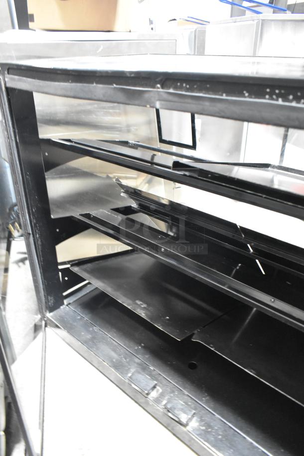 Metal countertop dry merchandiser display case with shelves, 115 volts, 1 phase, black finish, used condition.