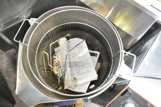 Groen stainless steel commercial steam kettle, floor style, with visible internal manual and debris, used condition.