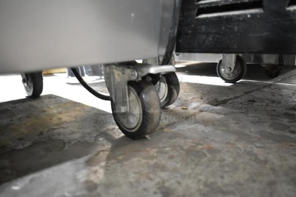 Stainless steel Vevor YKF-9228 soft serve ice cream machine on commercial casters, showing floor casters. 110V, 1 Phase.