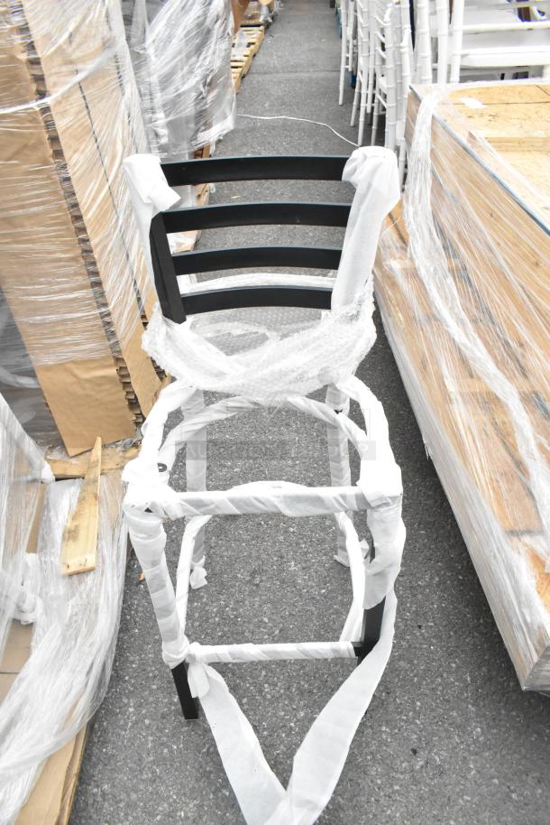 Black metal bar height ladder back chair frame, new with minor scratches and dents, wrapped in protective material.