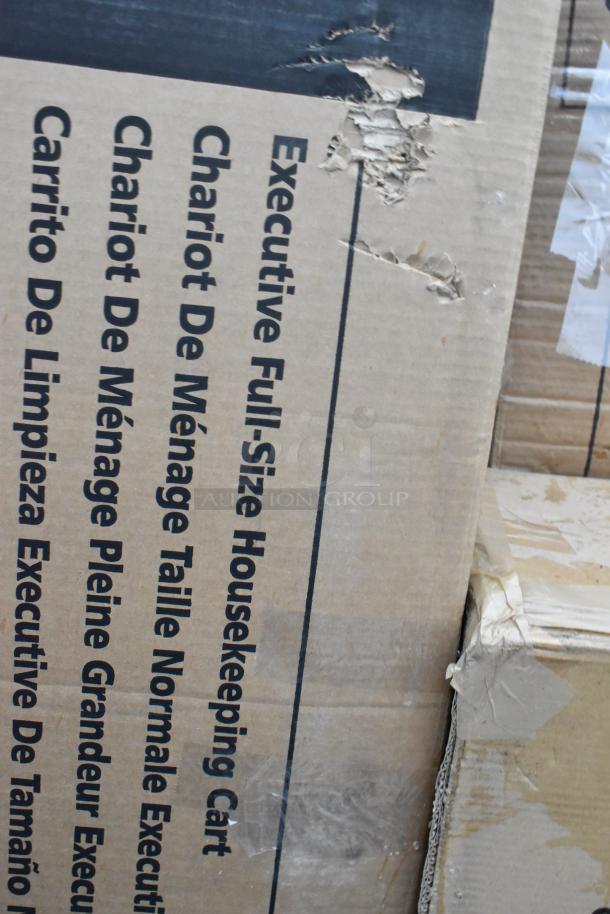 Cardboard box with "Executive Full-Size Housekeeping Cart" text, showing visible scratches and dents.