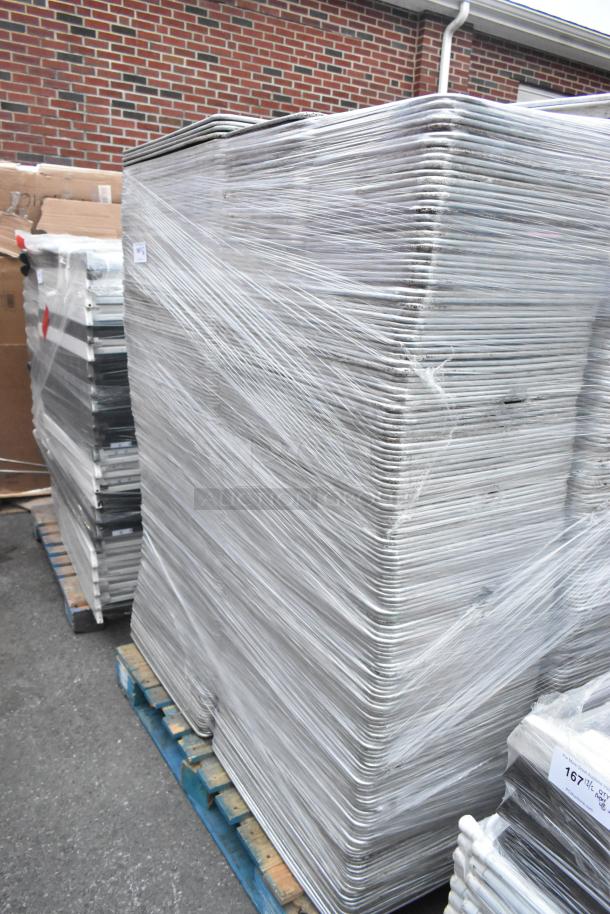 Stack of 600 metal full-size baking pans wrapped in plastic on pallets, suitable for high-volume baking needs.